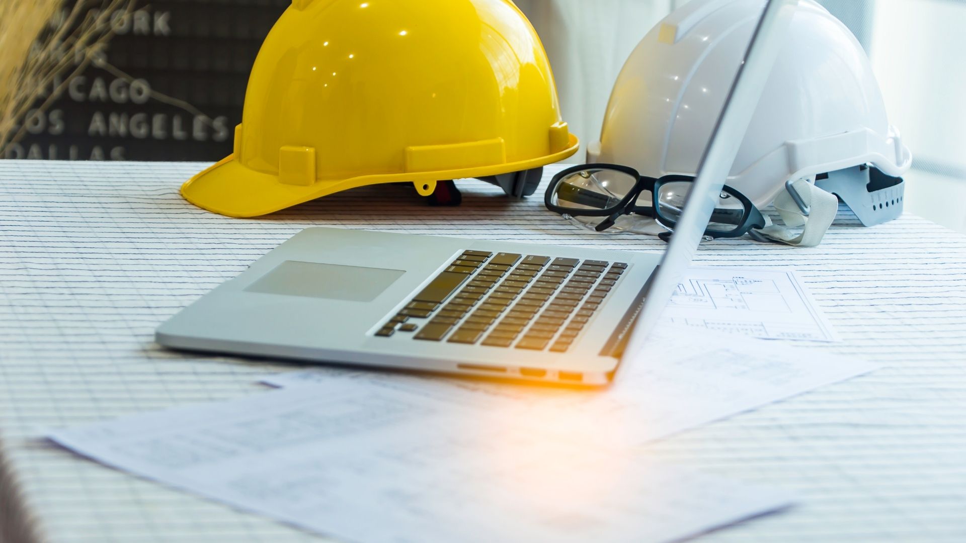 Professional workspace with safety equipment, hard hats, and technology tools